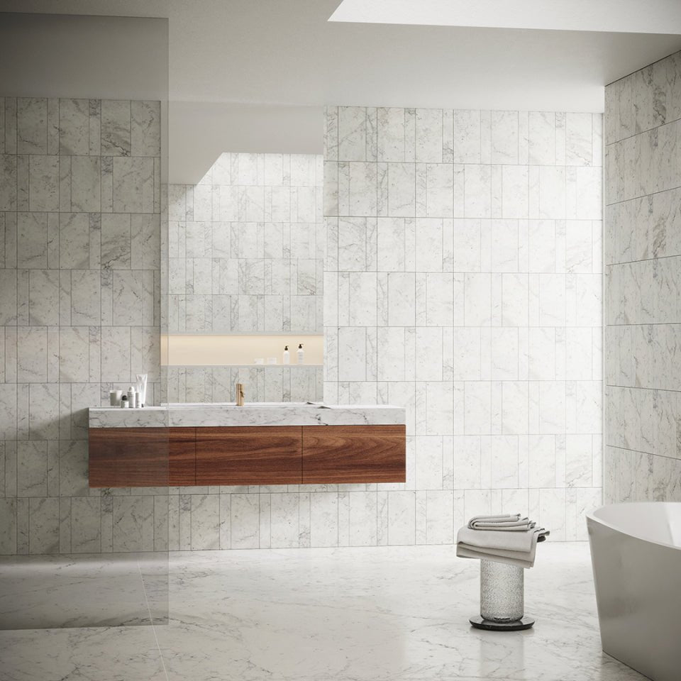 Carrara Marble Wall Mounted Vanity Unit styled in a luxury bathroom with brushed brass tapware and marble wall tiles
