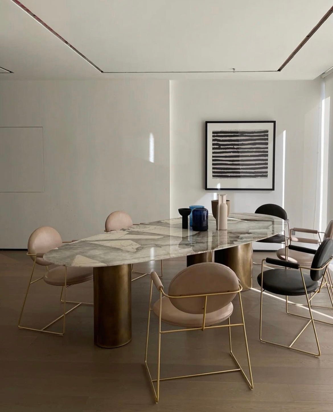 Sienna Patagonia quartzite oval dining table styled in contemporary dining room — stone top and brass legs
