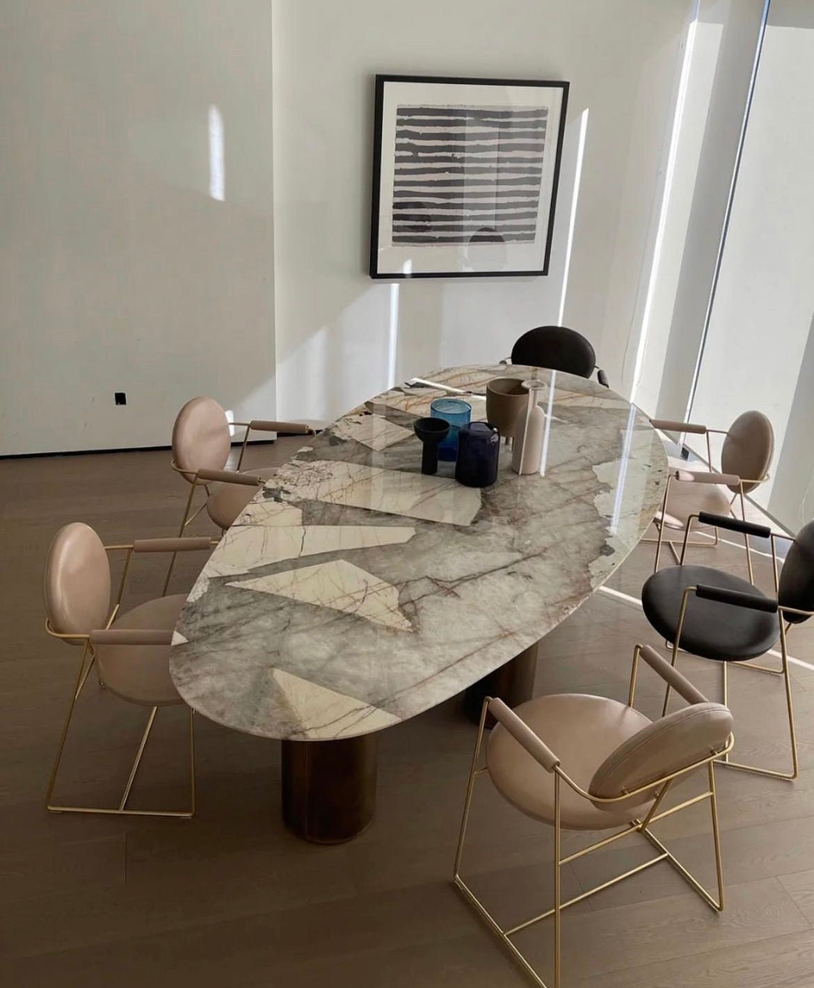 Sienna Patagonia quartzite oval dining table angled view showing brushed brass cylinder legs and oval stone profile