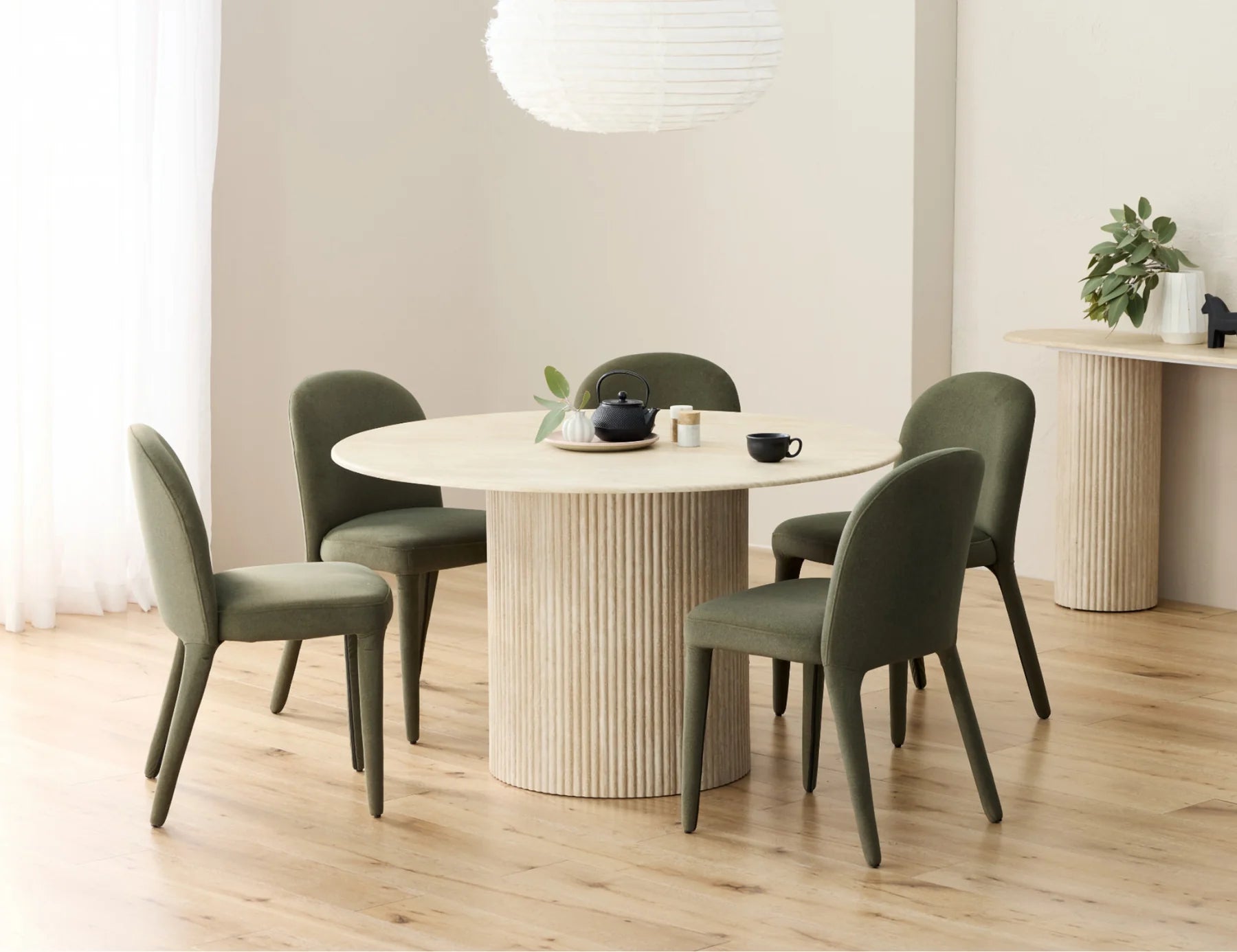 Travertine round dining table with fluted base and olive chairs