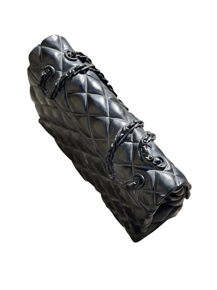 Marble carved luxury bag sculpture, showcasing detailed quilted pattern and chain strap. Elegant home decor.