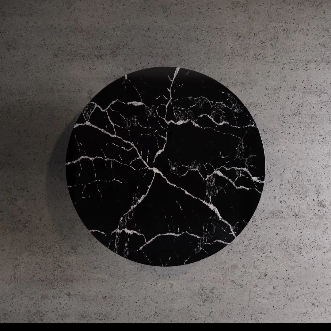 Amara Nero Marquina round dining table top view showing tapered edge profile and fluted pedestal