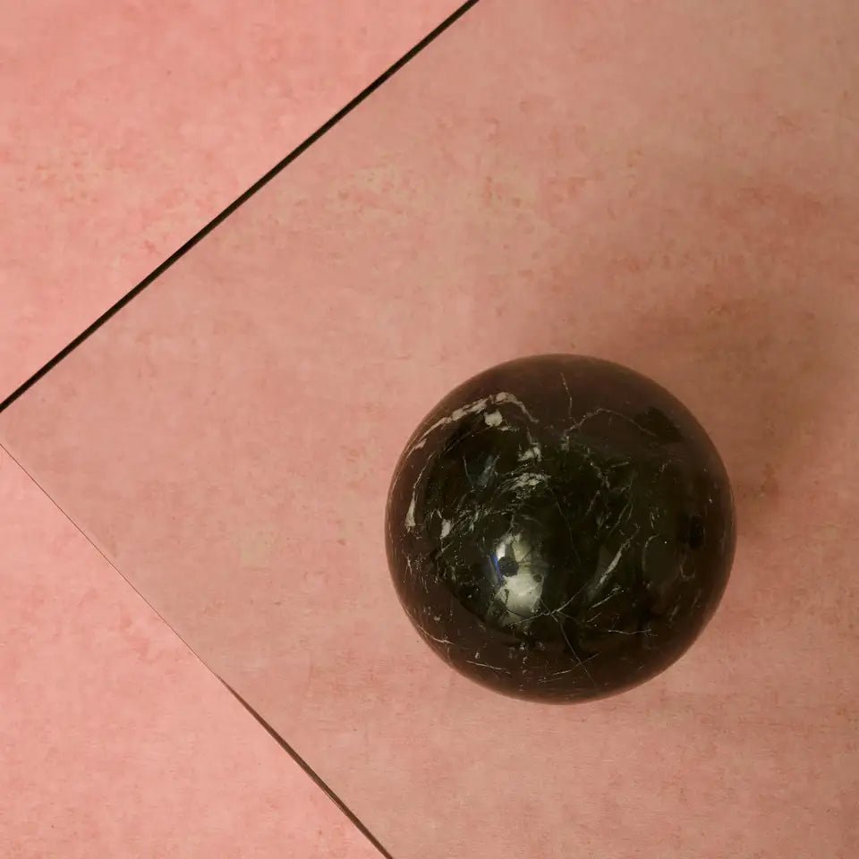 Close up of Nero Marquina marble pyramid and sphere showing deep black stone and white veining