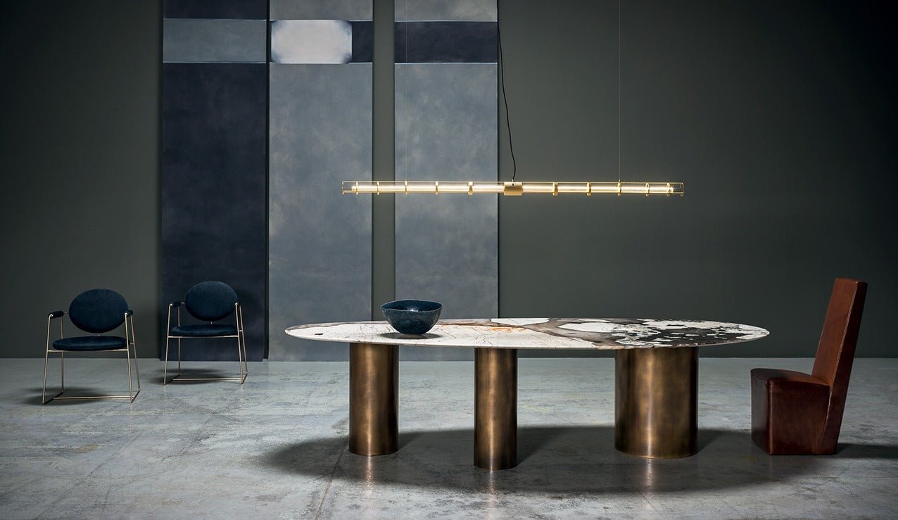 Sienna Patagonia quartzite oval dining table styled in dining room — brushed brass legs and natural stone top seats 12